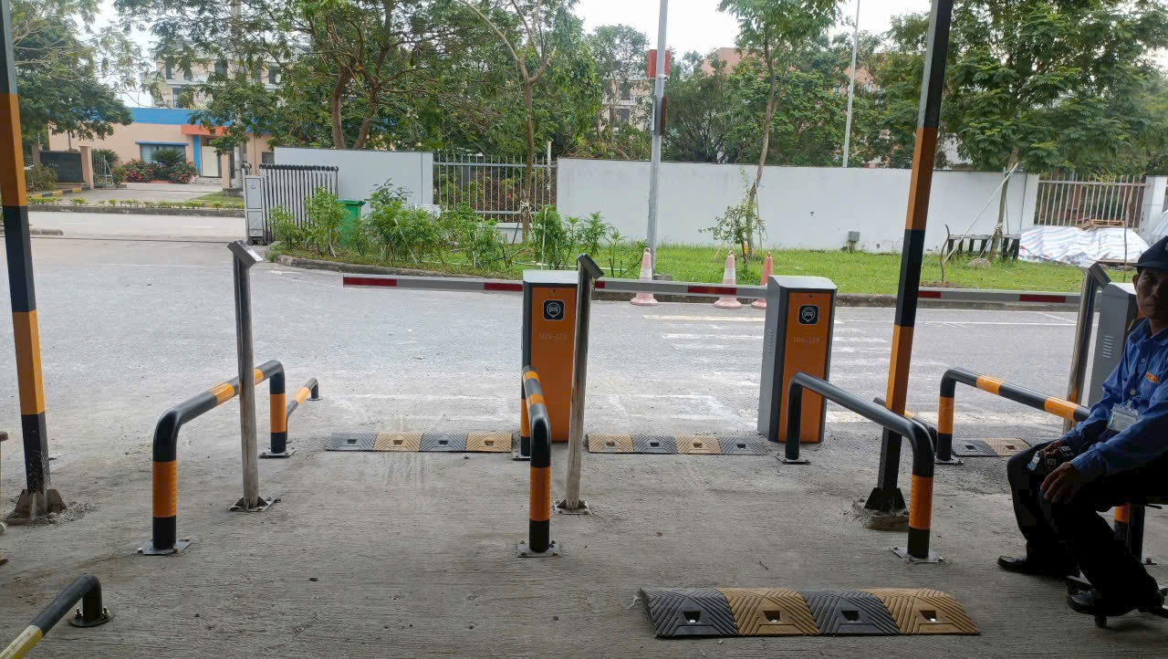 Hệ thống barie tự động kiểm soát lối ra vào bãi giữ xe với nhân viên bảo vệ ngồi bên cạnh